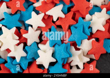 Rote, weiße und blaue sternförmige Süßigkeiten zum Dekorieren von Kuchen und anderem Gebäck, kleine sternförmige Süßwaren Stockfoto