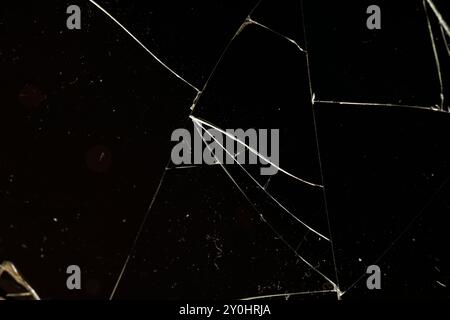 Verschmutztes Glas, das in eine große Anzahl von Teilen zerbrochen ist, ein Stück Glas mit vielen Rissen und gebrochenen Teilen Stockfoto