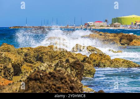 Wunderschöner Blick auf große Wellen des Karibischen Meeres, die gegen einen künstlichen Wellenbrecher stürzen. Curacao. Stockfoto