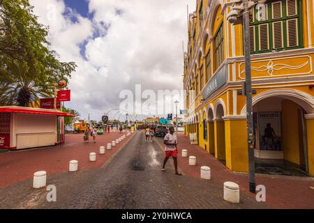 Willemstad Stadtzentrum auf Curacao mit Fußgängerzone zwischen historischer Architektur und der Queen Emma Bridge über Sint Anna Bay. Willemstad. Stockfoto