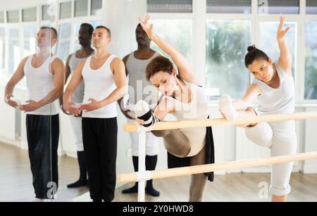 Frauen, die Dehnungsübungen in der Ballettbarre im Studio durchführen Stockfoto