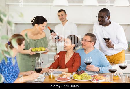 Multiethnische Frauen und Männer, die sich unterhalten und trinken Stockfoto