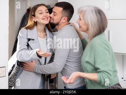 Die Familie begrüßte und umarmte Frau, die nach der Geschäftsreise kam Stockfoto