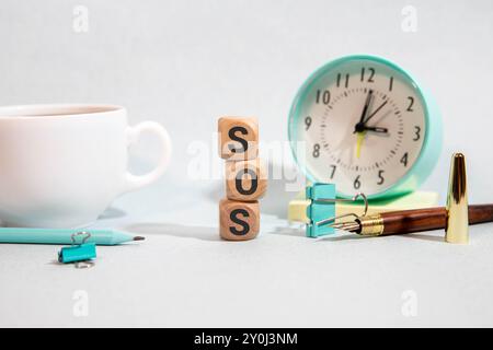 SOS-Text auf Holzwürfeln auf einem isolierten Tisch, medizinisches Konzept. Stockfoto