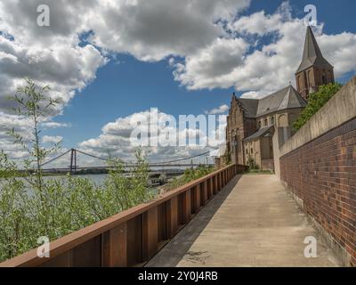 Kirche entlang eines Wanderweges mit Blick auf eine Brücke und Wolken am Himmel, emmerich, niederrhein, deutschland Stockfoto