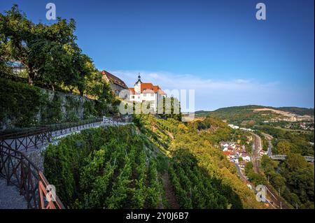 Ein Weg entlang eines Hügels, flankiert von der alten Burg der Dornburg Burgen und ein weicher Blick über das Tal unter klarem Himmel, Dornburg-Camburg, Thuring Stockfoto