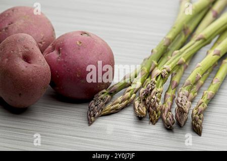 Eine Nahaufnahme roher roher roher roter Kartoffeln und roher Spargel im Studio Stockfoto