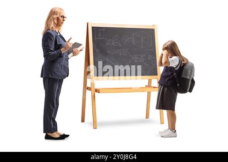 Profilaufnahme eines Lehrers, der mit einem traurigen Schulmädchen vor einer Tafel spricht, isoliert auf weißem Hintergrund Stockfoto