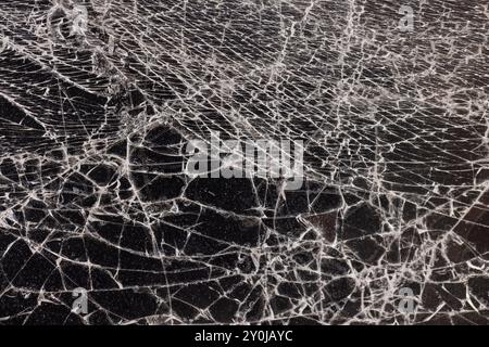 Glas zerbrochen in eine große Anzahl von Stücken und Rissen, ein Stück Glas mit einer großen Anzahl von Rissen und gebrochenen Teilen Stockfoto