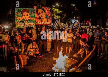 Demonstranten halten Schilder mit den Porträts von Carmel Gat, r und Hersh Goldberg Polin während eines Protestes in Jerusalem nach der Beerdigung von Hersh am Montag, 2. September 2024. Zehntausende Menschen haben sich für einen zweiten Tag in Israel versammelt, nachdem die Leichen von Karmel Gat, Eden Yerushalmi, Hersh Goldberg-Polin, Alexander Lobanov, Almog Sarusi und Meister Sgt Ori Danino aus Gaza gerettet wurden. Die Demonstranten rufen Premierminister Benjamin Netanjahu und seine Regierung auf, eine Einigung zu erzielen, um die Freilassung der verbleibenden Geiseln zu erreichen, die die Hamas während der Angriffe vom 7. Oktober ergriffen hat. Foto von Eyal Warshavsky. Stockfoto