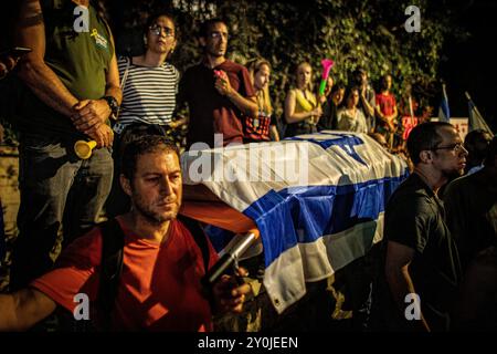 Ein Demonstrant hält während eines Protestes in Jerusalem nach der Beerdigung von Hersh Goldberg Polin am 2. September 2024 einen Scheinsarg. Zehntausende Menschen haben sich für einen zweiten Tag in Israel versammelt, nachdem die Leichen von Karmel Gat, Eden Yerushalmi, Hersh Goldberg-Polin, Alexander Lobanov, Almog Sarusi und Meister Sgt Ori Danino aus Gaza gerettet wurden. Die Demonstranten rufen Premierminister Benjamin Netanjahu und seine Regierung auf, eine Einigung zu erzielen, um die Freilassung der verbleibenden Geiseln zu erreichen, die die Hamas während der Angriffe vom 7. Oktober ergriffen hat. Foto von Eyal Warshavsky. Stockfoto