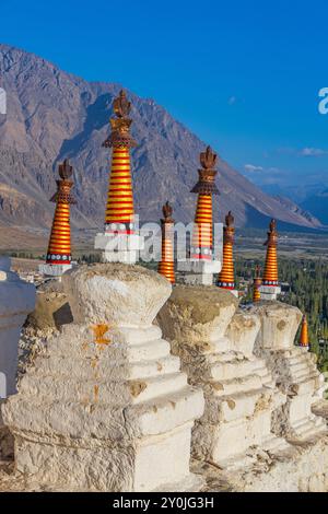 Viele weiße Stupas in einer Reihe auf einem Berg mit blauem Himmel im Hintergrund Stockfoto