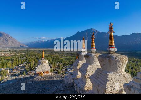 Viele weiße Stupas in einer Reihe auf einem Berg mit blauem Himmel im Hintergrund Stockfoto