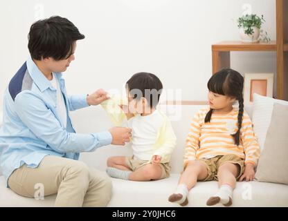 Vater hilft einem Jungen, sich umzuziehen Stockfoto