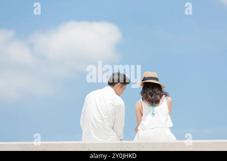 Pärchen sitzen auf dem Wellenbrecher Stockfoto