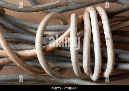 Alte elektrische Drähte oder Kabel in Nahaufnahme, Stapel von entsorgten weißen und grauen, schmutzigen Hauskabelkabeln im selektiven Fokus direkt von oben Stockfoto