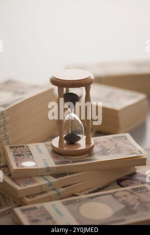 Ein Wattestäbchen mit zehntausend Yen-Noten und sandglas Stockfoto
