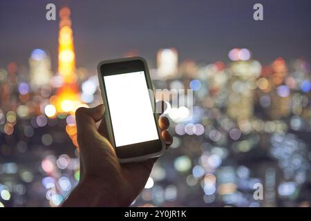 Nachtblick auf Tokio und ein Smartphone Stockfoto