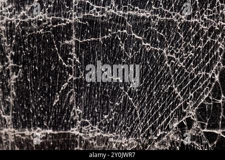 Verschmutztes Glas, das in eine große Anzahl von Teilen zerbrochen ist, ein Stück Glas mit vielen Rissen und gebrochenen Teilen Stockfoto