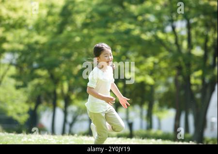 Mädchen, die auf dem Park-Rasen spielt Stockfoto