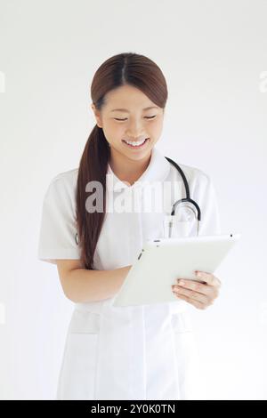 Schwester lächelt mit einem Tablet-PC Stockfoto