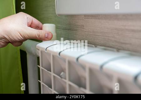 Handabsenktemperatur einer Heizbatterie. Temperaturregler des Kühlers der Wasserheizung im Raum. Einstellung von Wärme und Stockfoto