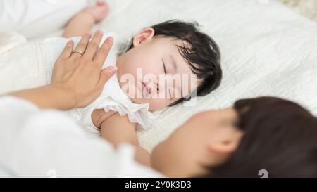 Mutter sieht ihr Baby beim Schlafen zu Stockfoto