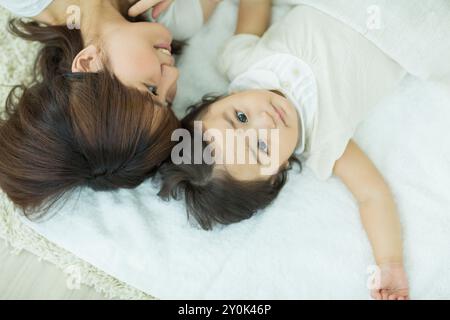 Mutter mit ihrem Baby, das sich hinlegt Stockfoto