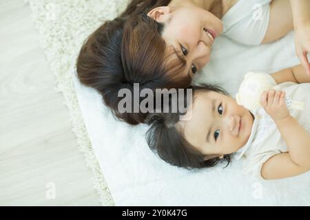 Mutter mit ihrem Baby, das sich hinlegt Stockfoto