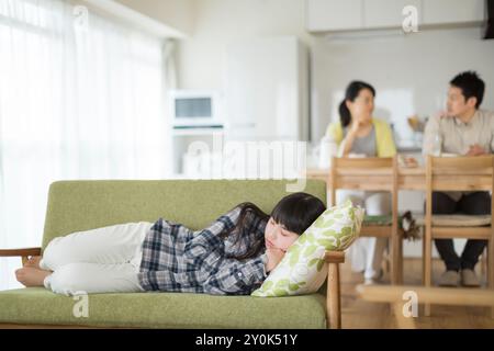 Mädchen, das auf einer Couch liegt und ein Nickerchen macht Stockfoto