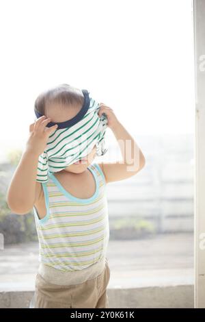 Der Junge, der versucht, sich selbst zu kleiden Stockfoto