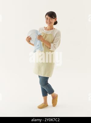 Die Hausfrau wischt einen Teller ab Stockfoto