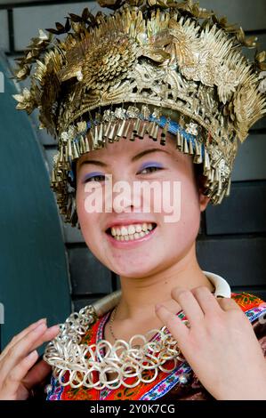 Porträt einer lächelnden Chinesin in einem Miao-Minderheitenkostüm. Foto in Nanjing, China. Stockfoto