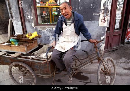 Ein Mann ruht in einer engen Straße in der Altstadt von Ping Yao. Shanxi, China Stockfoto