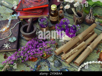 Mystisches Stillleben mit Zauberbuch, Heilkräutern und Hexenritualgegenständen auf altem Tisch. Okkultes, esoterisches, Wicca- und Wahrsagungskonzept. Nein Stockfoto