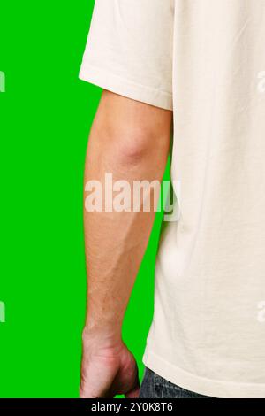 Eine Nahaufnahme einer Mans Hand in der Nähe seiner Tasche vor einem hellgrünen Hintergrund Stockfoto