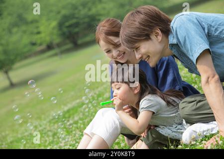 Japanische Familie spielt mit Seifenblasen Stockfoto