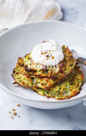 Zucchini-Pfannkuchen mit Sauerrahm. Rezeptkonzept für den Sommer. Stockfoto