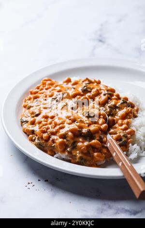 Cremiger Eintopf aus Tomaten und weißen Bohnen mit Reis. Stockfoto