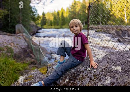 Holztreppe an einem Fluss, Familie mit Kindern besucht Schweden und Norwegen, Wandern in der Natur mit Hund im Sommer Stockfoto