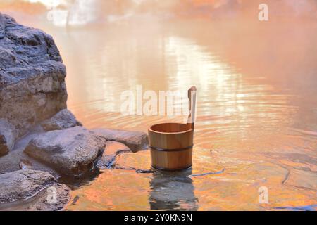 Heiße Quellen im Freien und ein Eimer mit Herbstlaub Stockfoto