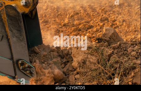 Metalleimer für Baggerlader, die Boden graben. Bagger arbeitet auf der Baustelle. Erdbewegungsmaschine. Aushubfahrzeug. Schwere Maschinen in Aktion. Stockfoto