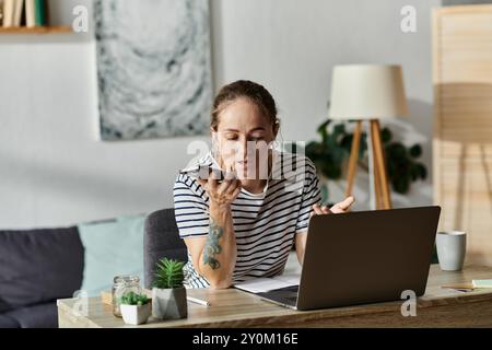 Junge Frau mit Vitiligo spricht aktiv am Smartphone in gemütlichem Arbeitsbereich. Stockfoto