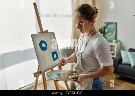 Eine talentierte Frau mit Vitiligo malt leidenschaftlich auf Leinwand in ihrem künstlerischen Raum. Stockfoto