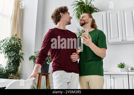 Ein fröhliches Paar lacht, während es sich in einer warmen Küchenatmosphäre umgibt. Stockfoto