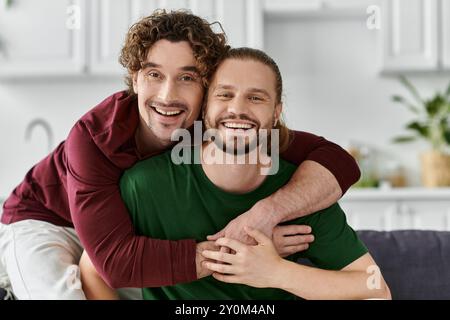 Ein fröhliches schwules Paar teilt eine liebevolle Umarmung in ihrem gemütlichen Zuhause. Stockfoto