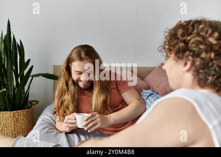 Ein liebevolles Paar teilt sich einen gemütlichen Moment bei einem Kaffee im Schlafzimmer. Stockfoto