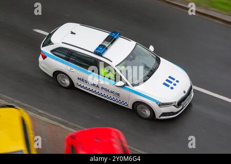 OSTRAVA, TSCHECHISCHE REPUBLIK - 24. APRIL 2024: Weißer Skoda Octavia Combi Stadtpolizeiwagen von Mestska Policie fährt mit Bewegungsunschärfe-Effekt Stockfoto