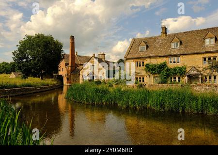 Das Lower Slaughter Museum und das Wasserrad entlang des malerischen River Eye in Bourton on the Water, Cotswolds, Gloucestershire, England, Großbritannien Stockfoto