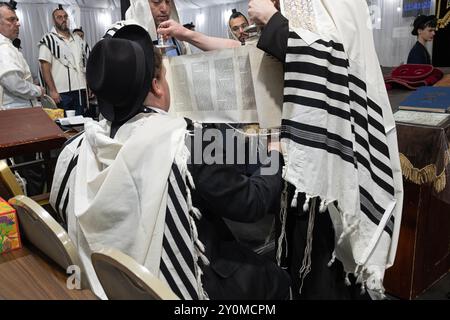 Nach einer Tora-Lesung wird die Schriftrolle hochgehoben, der Gemeinde gezeigt und wieder aufgezogen. Alle, die die Briefe sehen, werden gesegnet sein. In Monsey, New York. Stockfoto